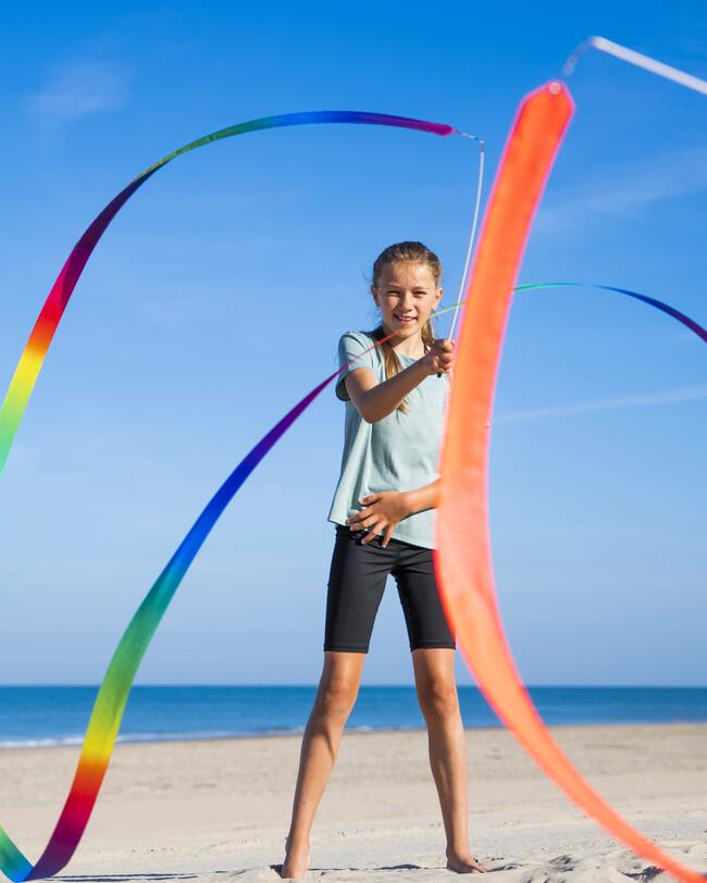 Ein Mädchen spielt am Strand mit einem Gymnastikband.