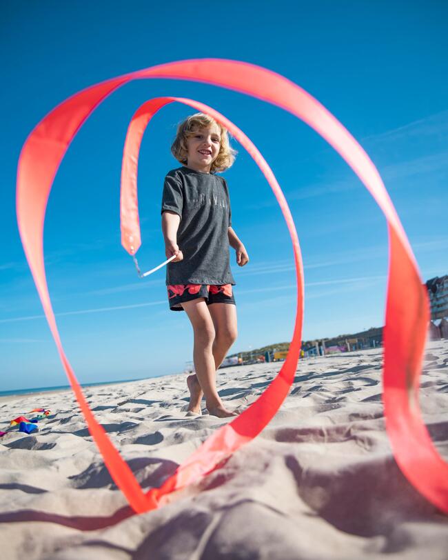 Ein Junge spielt am Strand mit einem Gymnastikband.
