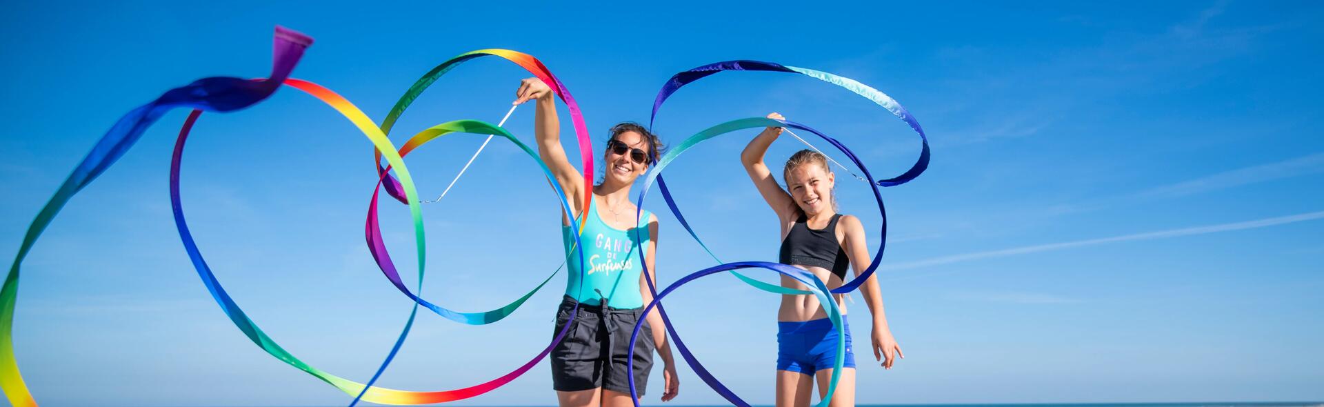Kobiety w strojach sportowych na plaży uprawiające gimnastykę