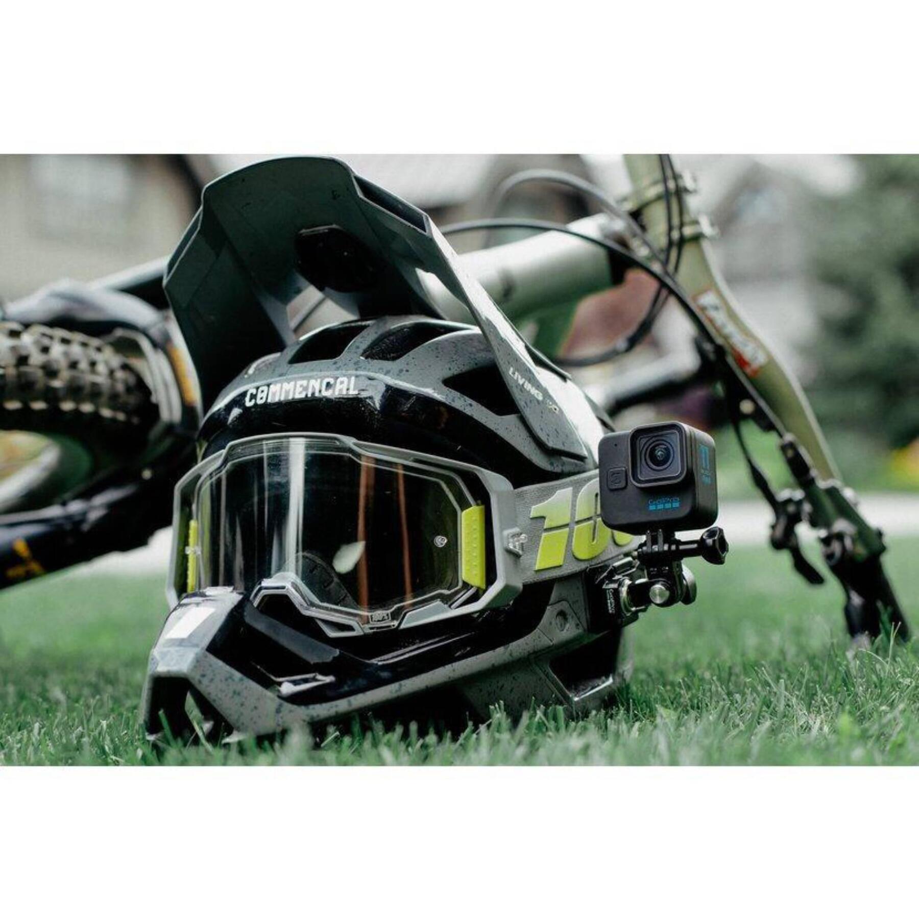 Kask rowerowy z zamontowaną kamerą rowerową leżący na trawie