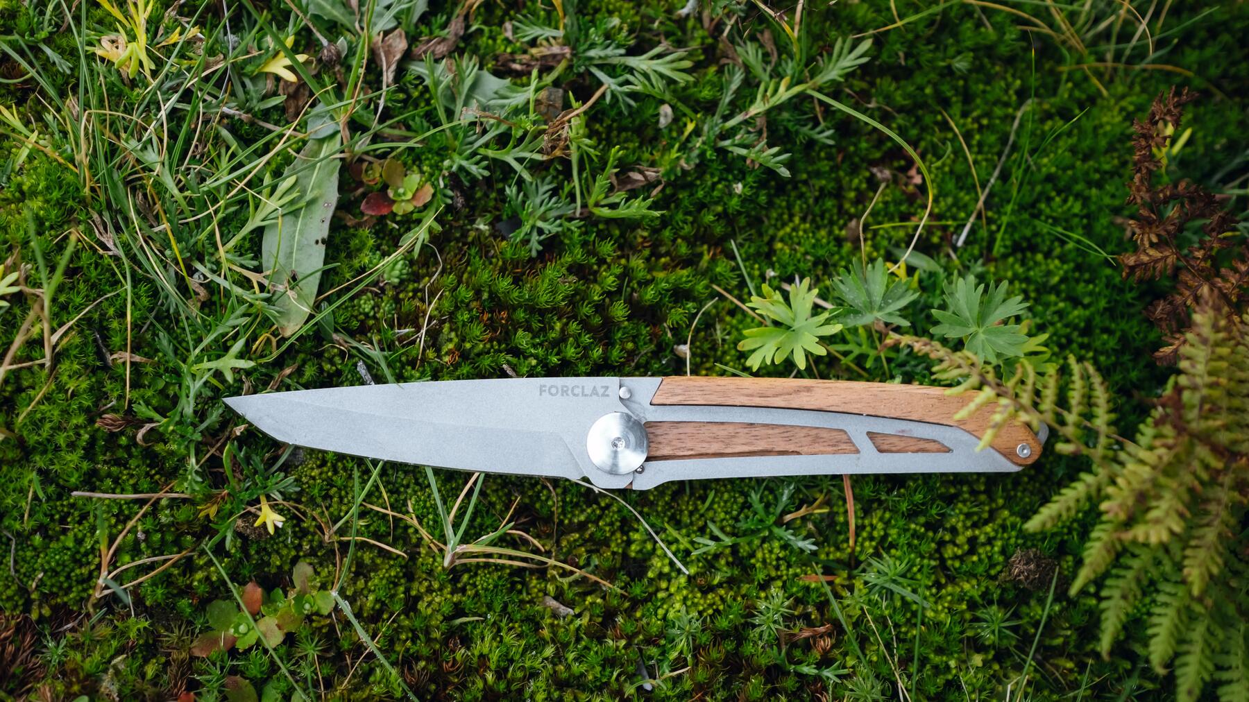 Nóż do lasu składany leżący na podłożu leśnym