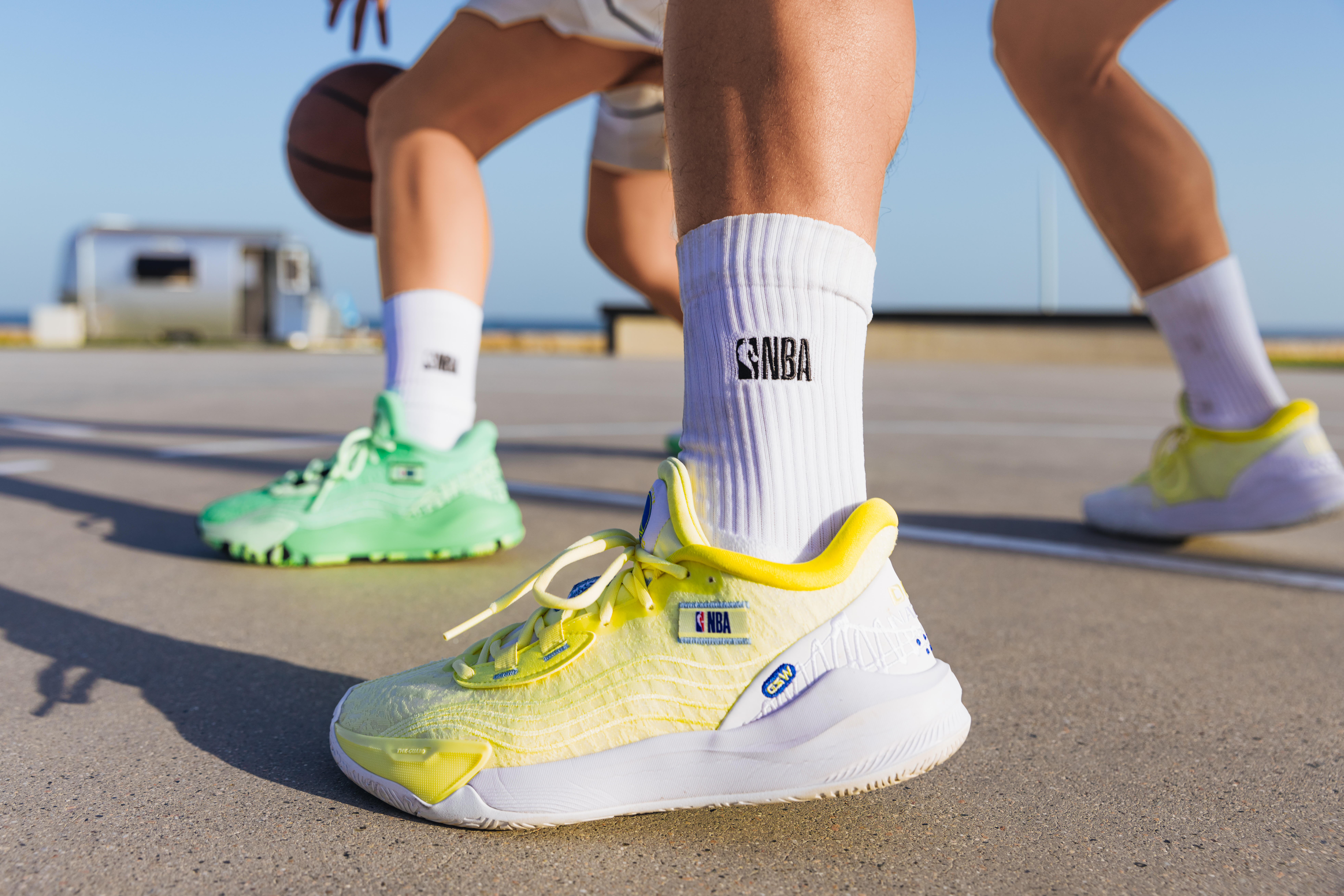 Basketball players wearing white crew socks and basketball shoes on an outdoor court