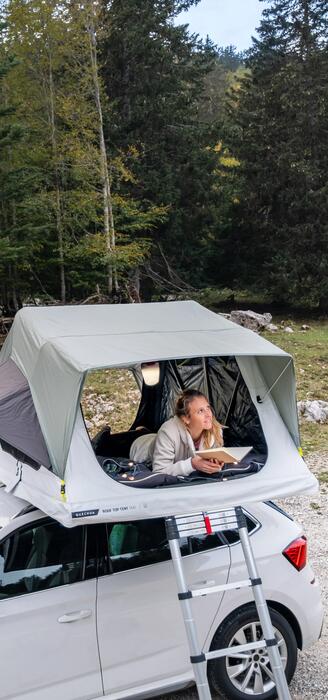 Žena ležiaca v strešnom stane na auto v prírode