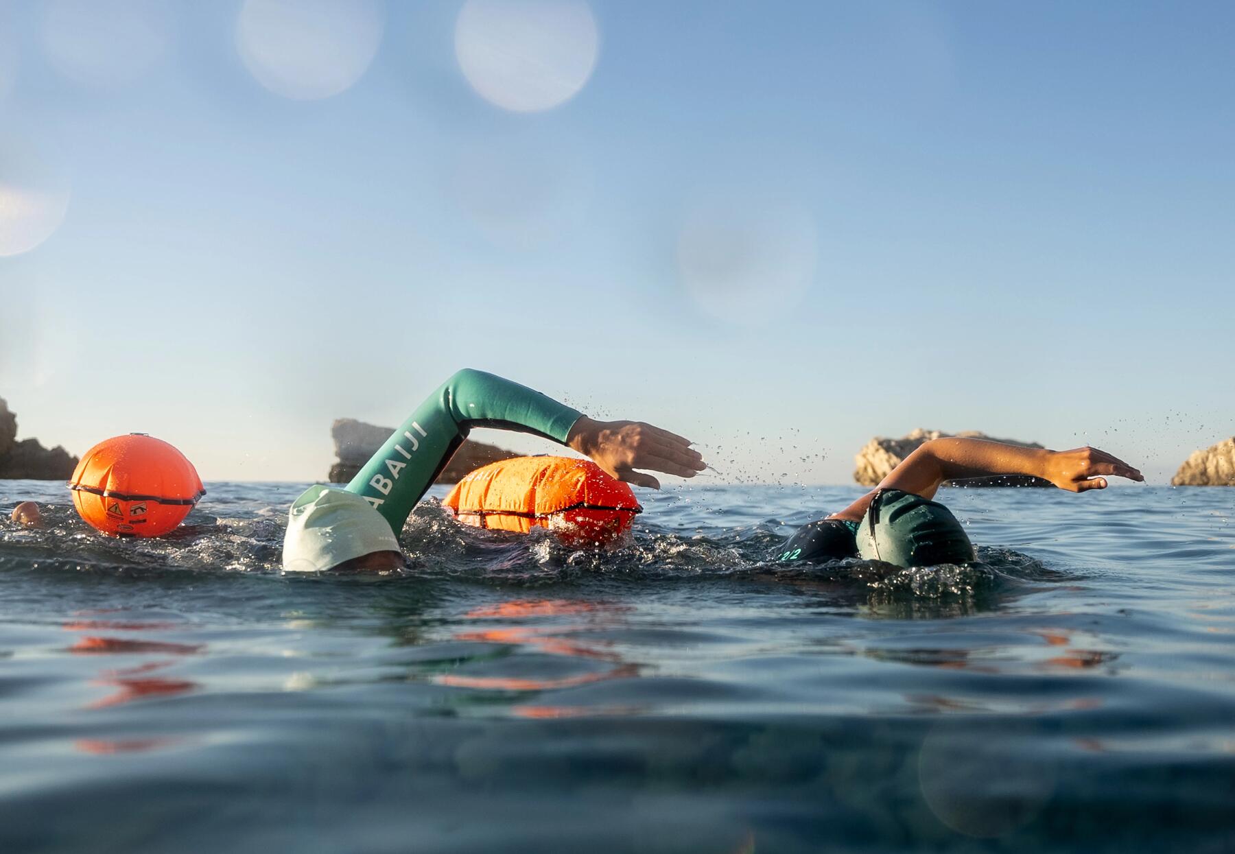 Triathlètes en train de courir dans l'eau en début de compétition de triathlon