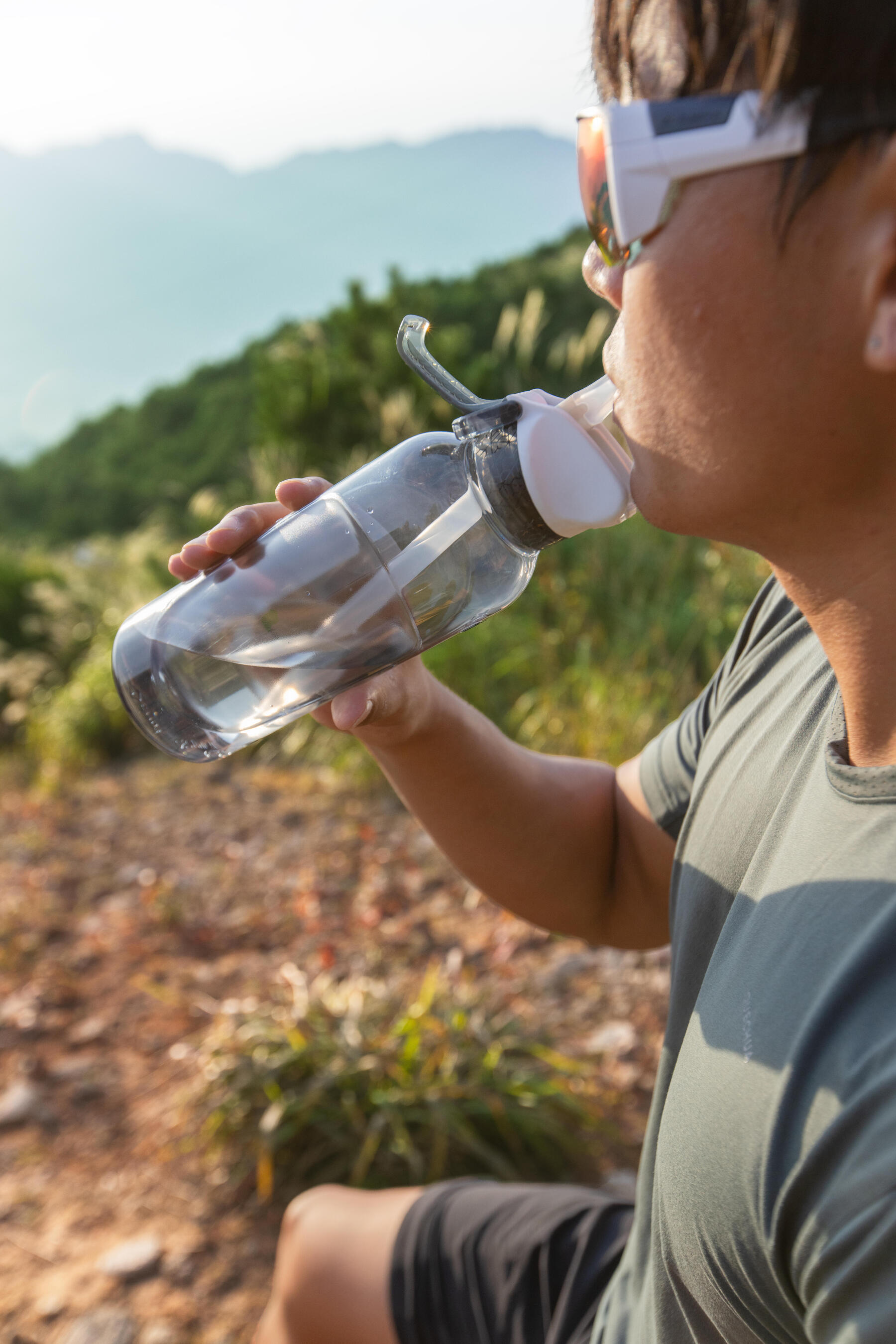 jeune fille qui boit de l'eau durant une randonnée