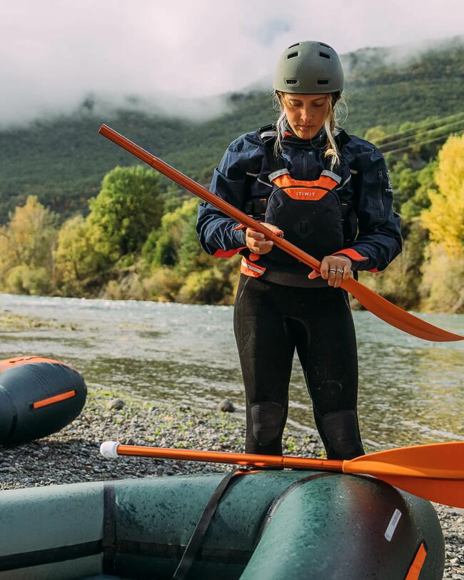 femme sur la plage avec un kayak elle porte un casque de protection