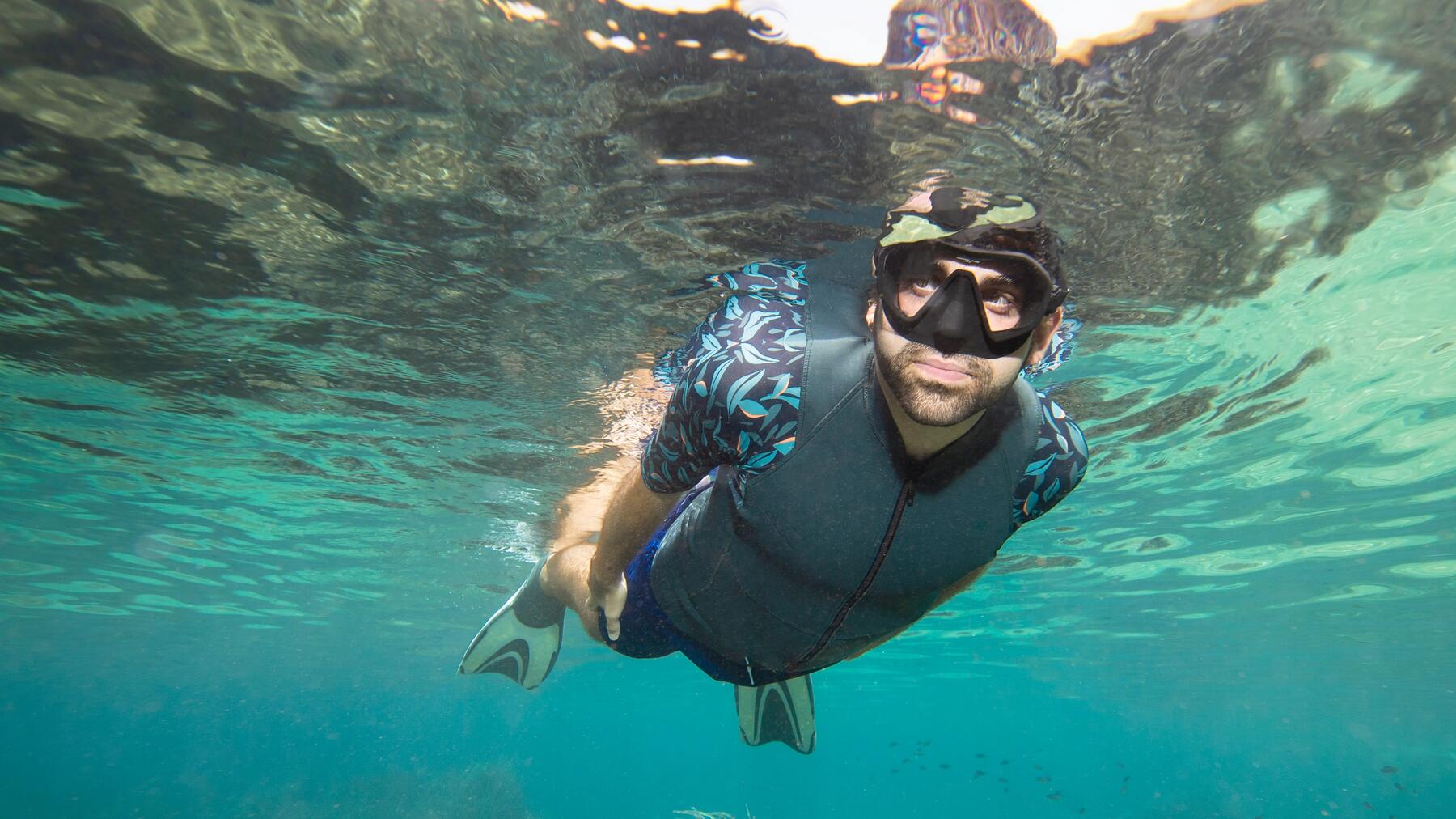 Mann taucht im Wasser mit Flossen