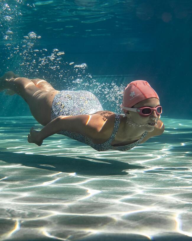 Kind taucht im Pool, Badeanzug, Schwimmbrille, Badekappe
