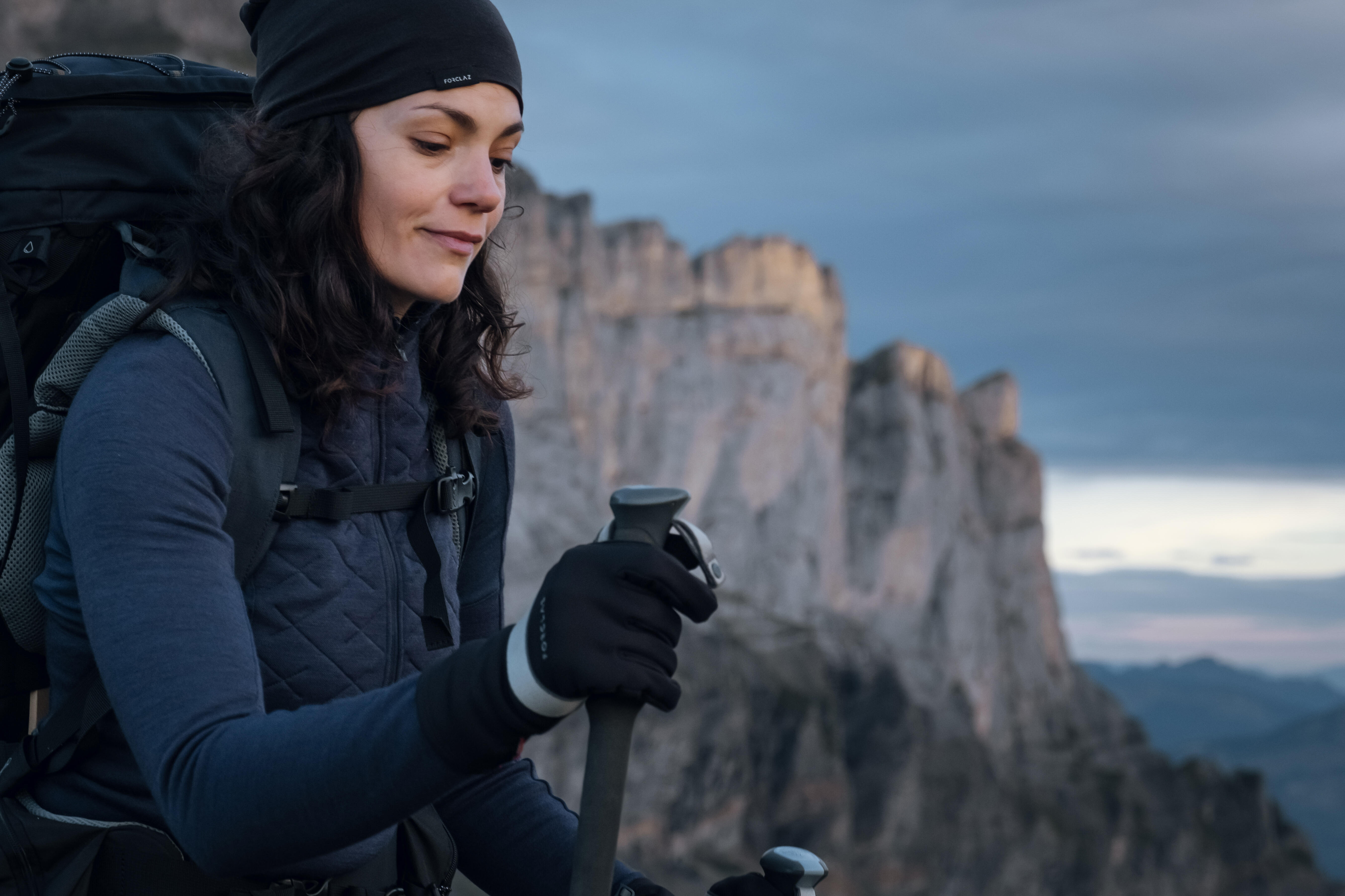 Woman in merino wool thermals, beanie and gloves hiking in the mountains