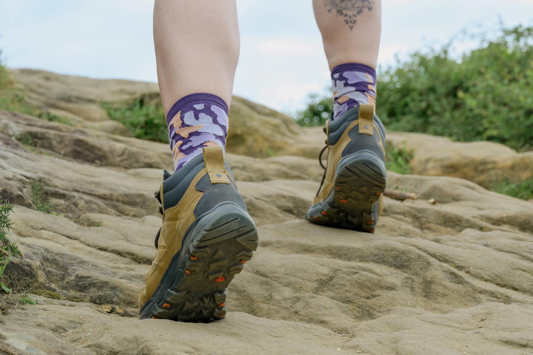 Osoba idąca w butach trekkingowych po kamieniach