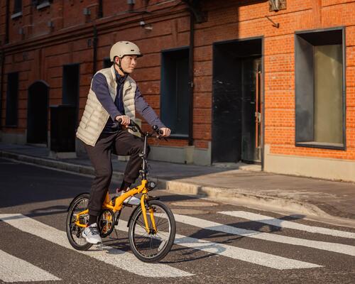 Iemand die op straat in de stad rijdt op een plooifiets