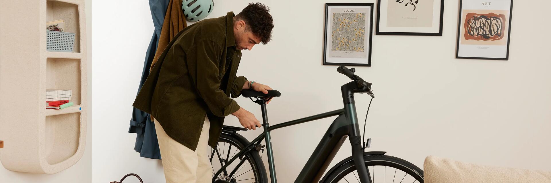 Mężczyzna składający rower dokręcający siodełko