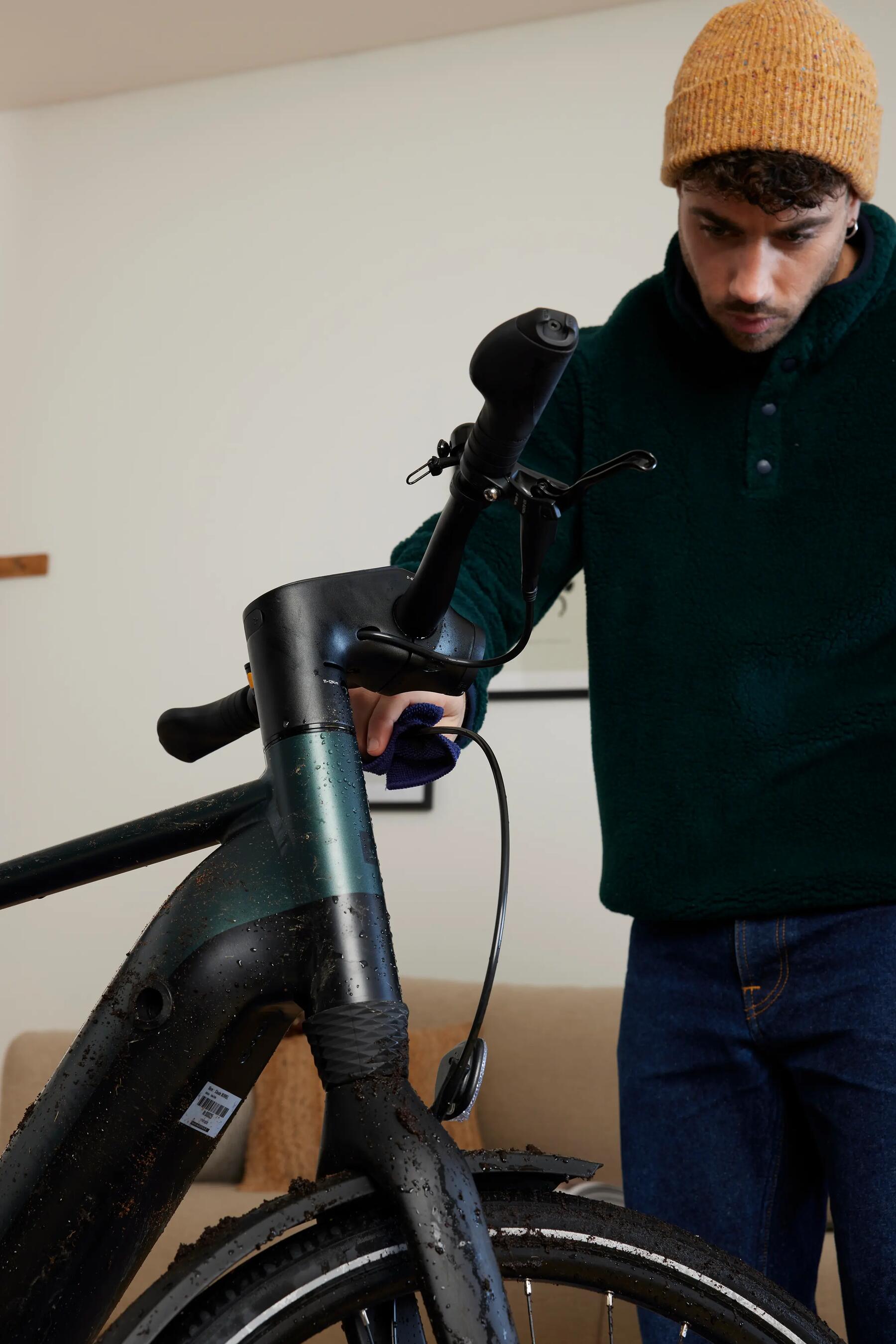 Mężczyzna czyszczący linki hamulcowe w rowerze elektrycznym 