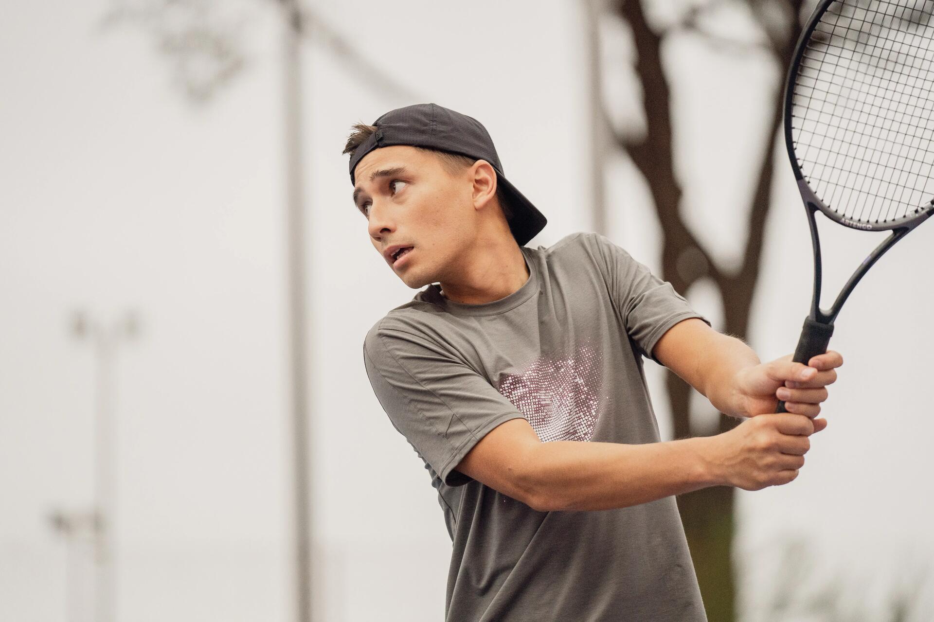 little boy with his tennis racket on the court
