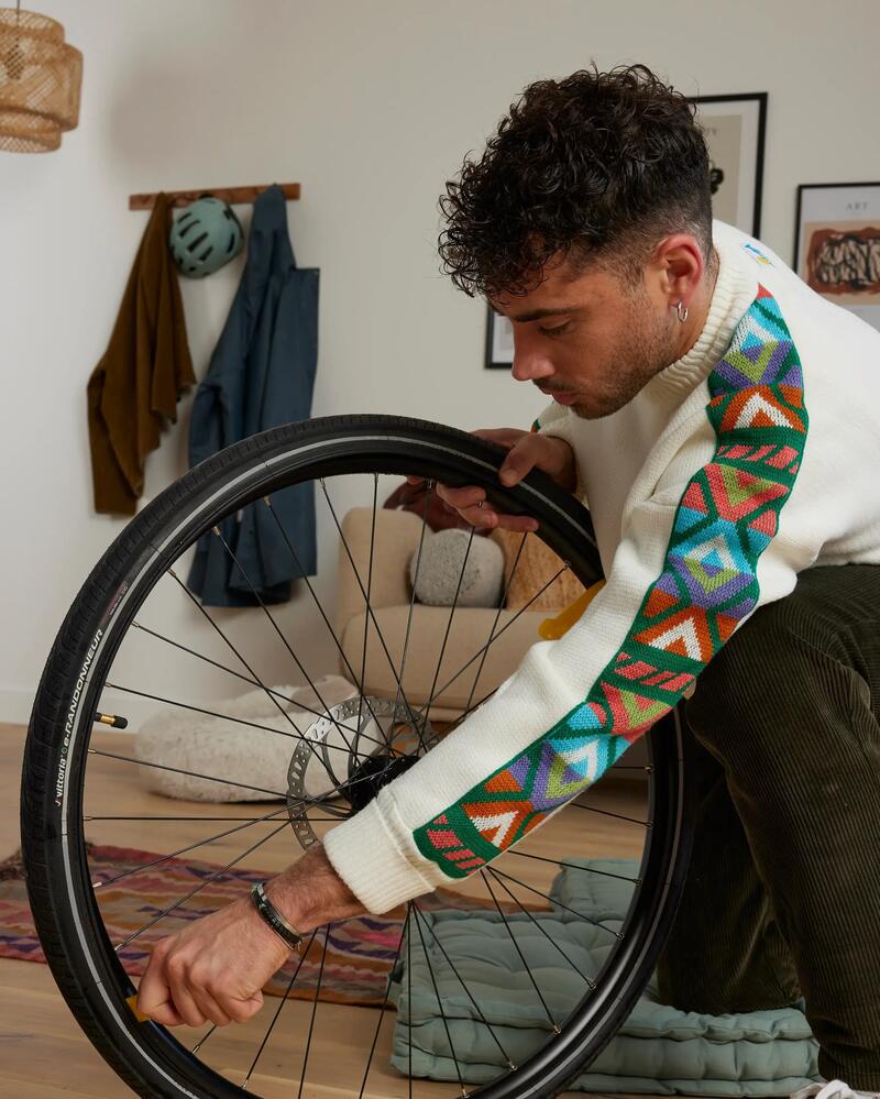 Eine Person arbeitet an einem augebauten Rad eines Fahrrads zu Hause