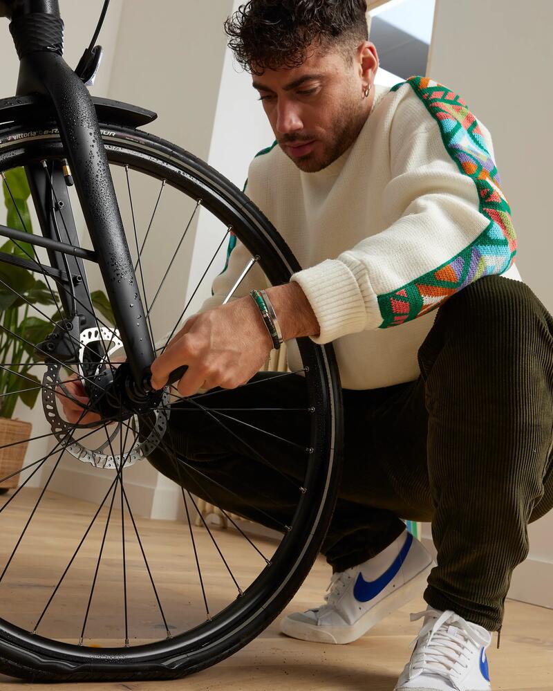Eine Person arbeitet an einem Vorderrad von einem Fahrrad