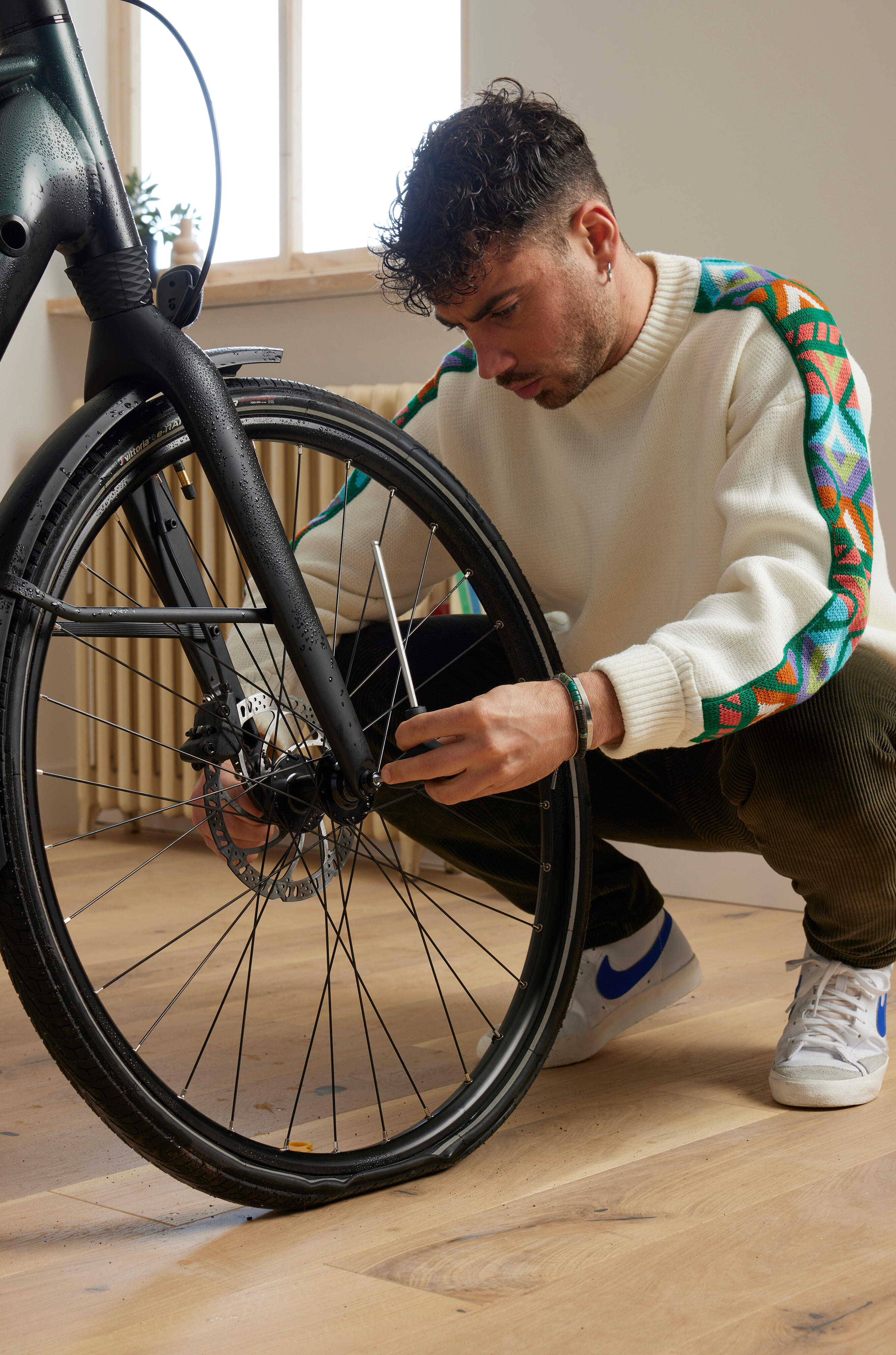 Ein Mann der etwas an ein Fahrrad schraubt.