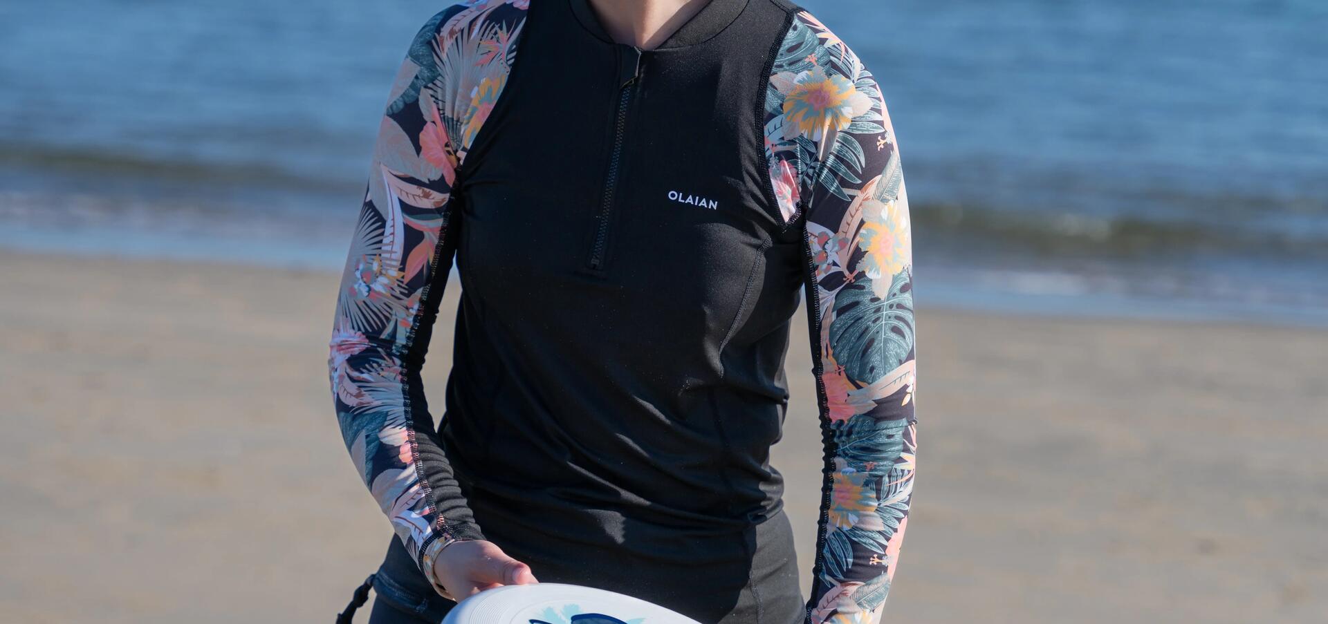 kobieta w stroju sportowym łapiąca frisbee na plaży
