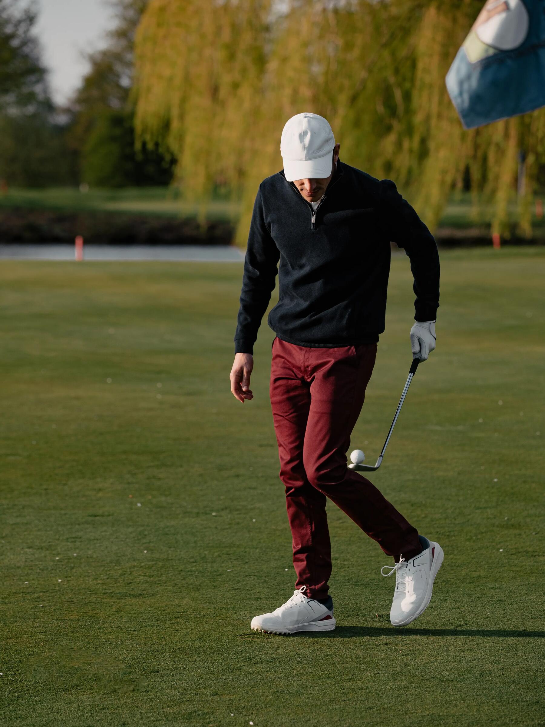 Golfista w butach do golfa idący po polu golfowym
