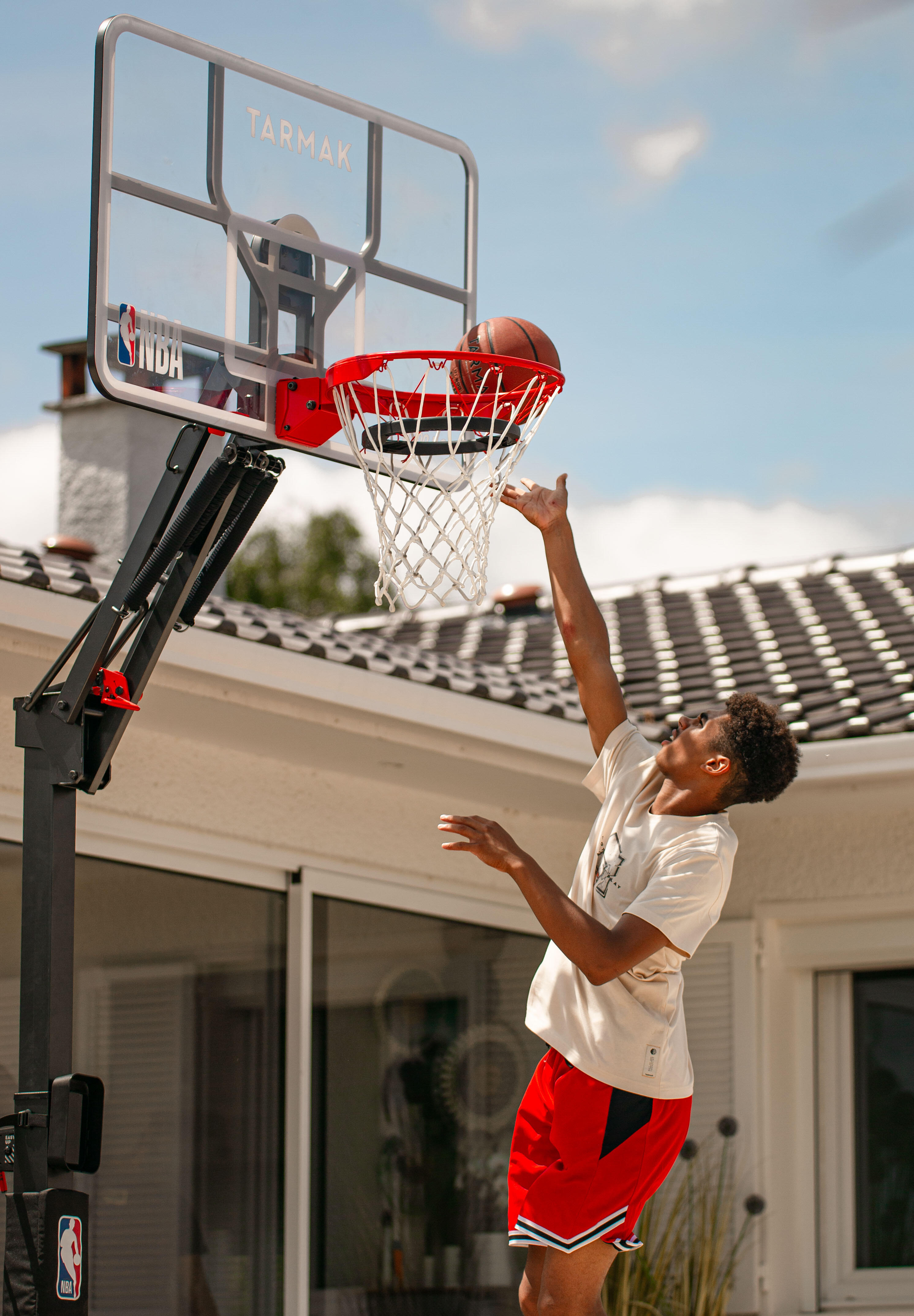 Ein junger Mann springt hoch, um einen Basketball in einen Korb zu werfen.