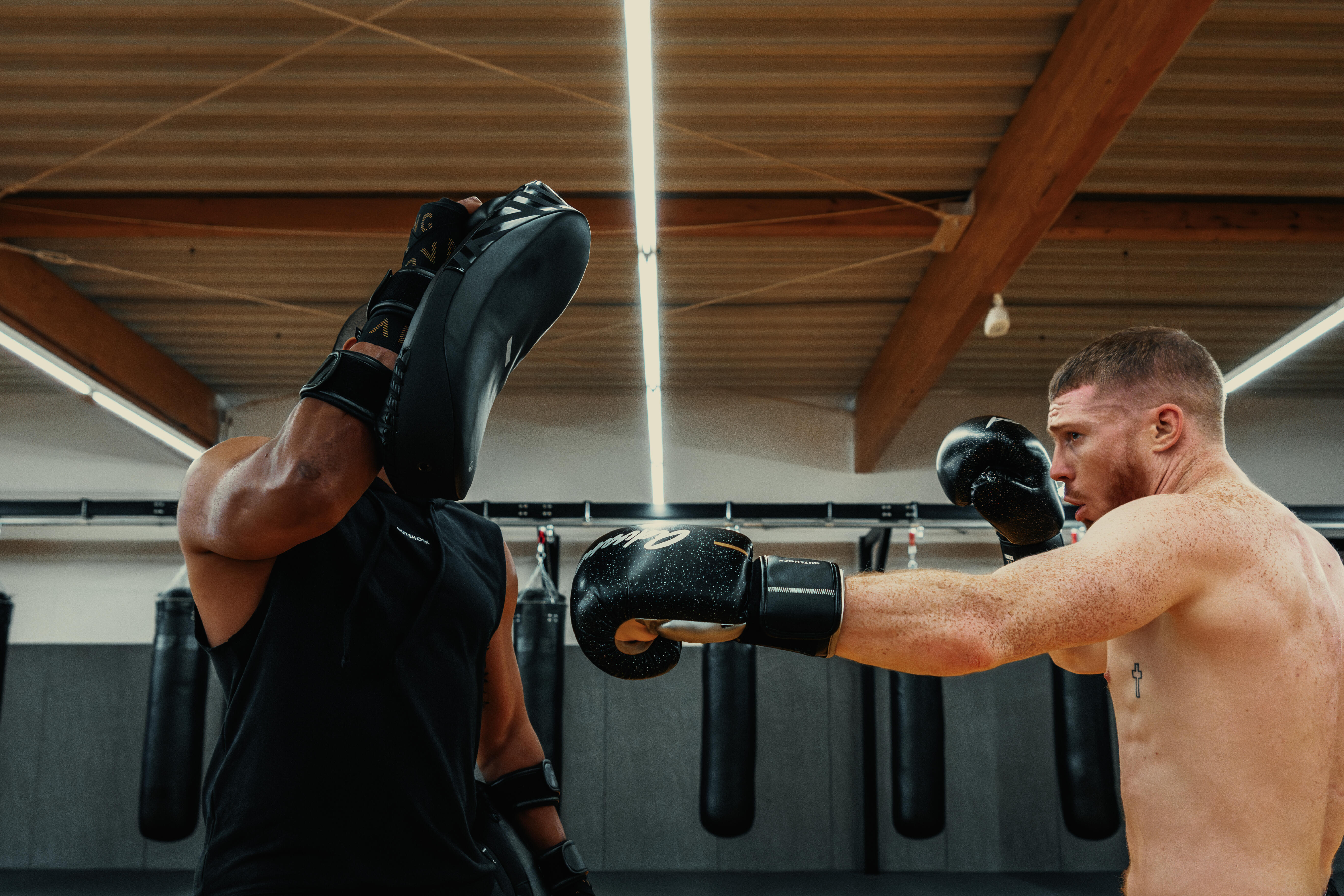 Boxer punching black boxing pads during training