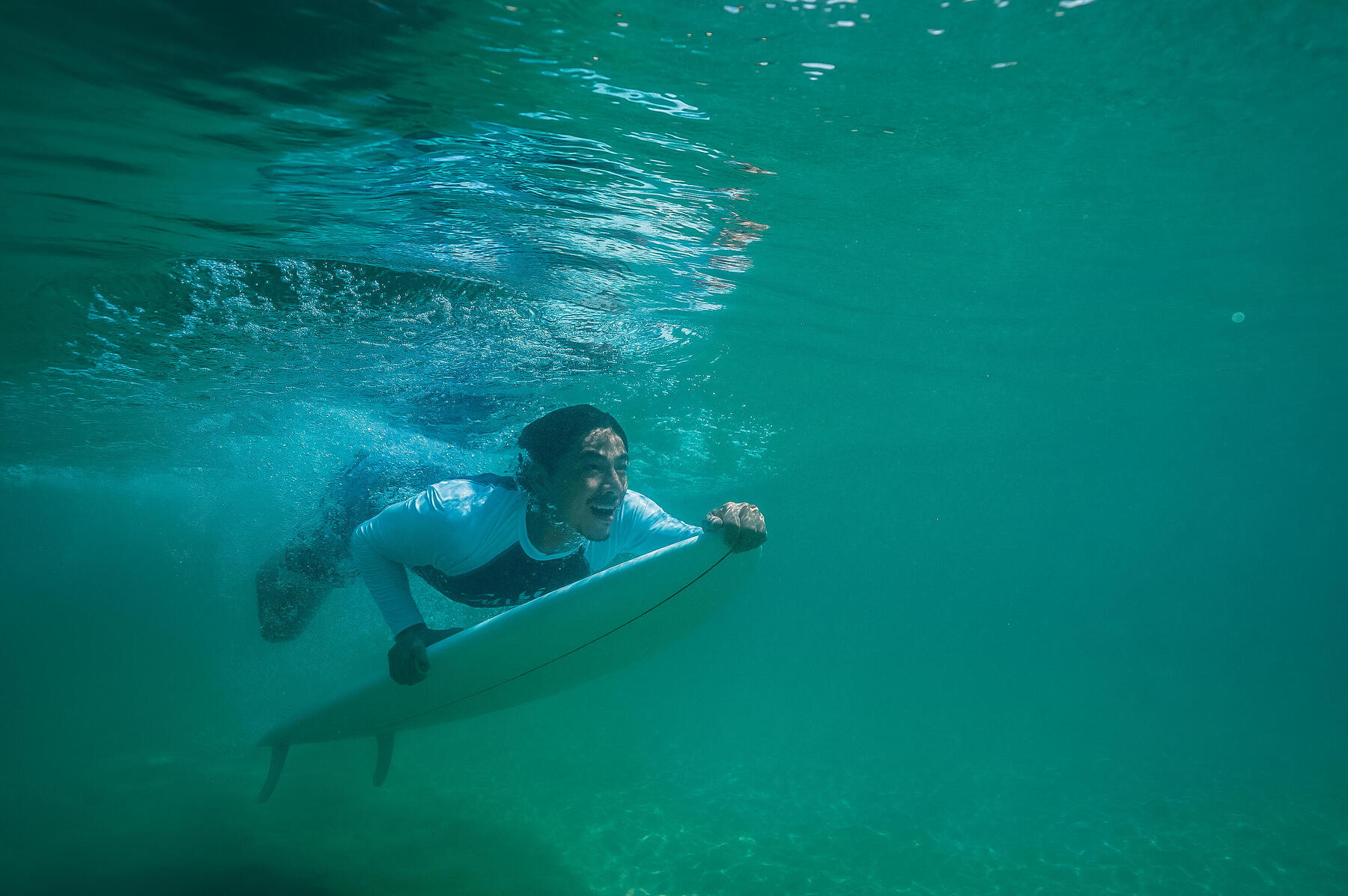 Mężczyzna pływający pod wodą na surfingu w Polsce