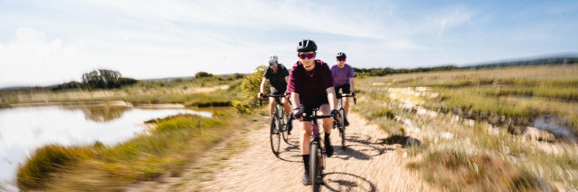 mężczyzna jadący na rowerze typu gravel w kasku i okularach rowerowych