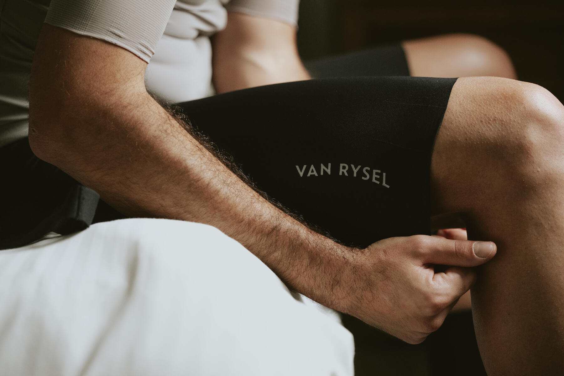 A close up of a cyclist massaging their leg