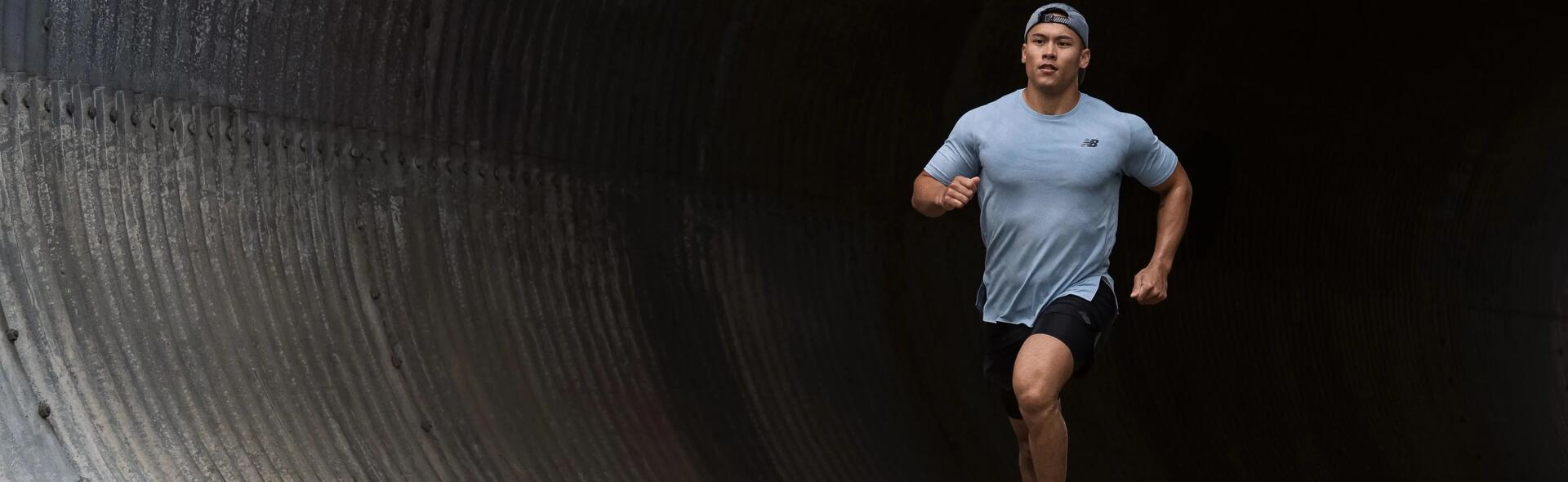 mężczyzna w czapce z daszkiem i butach do biegania biegnący przez tunel 