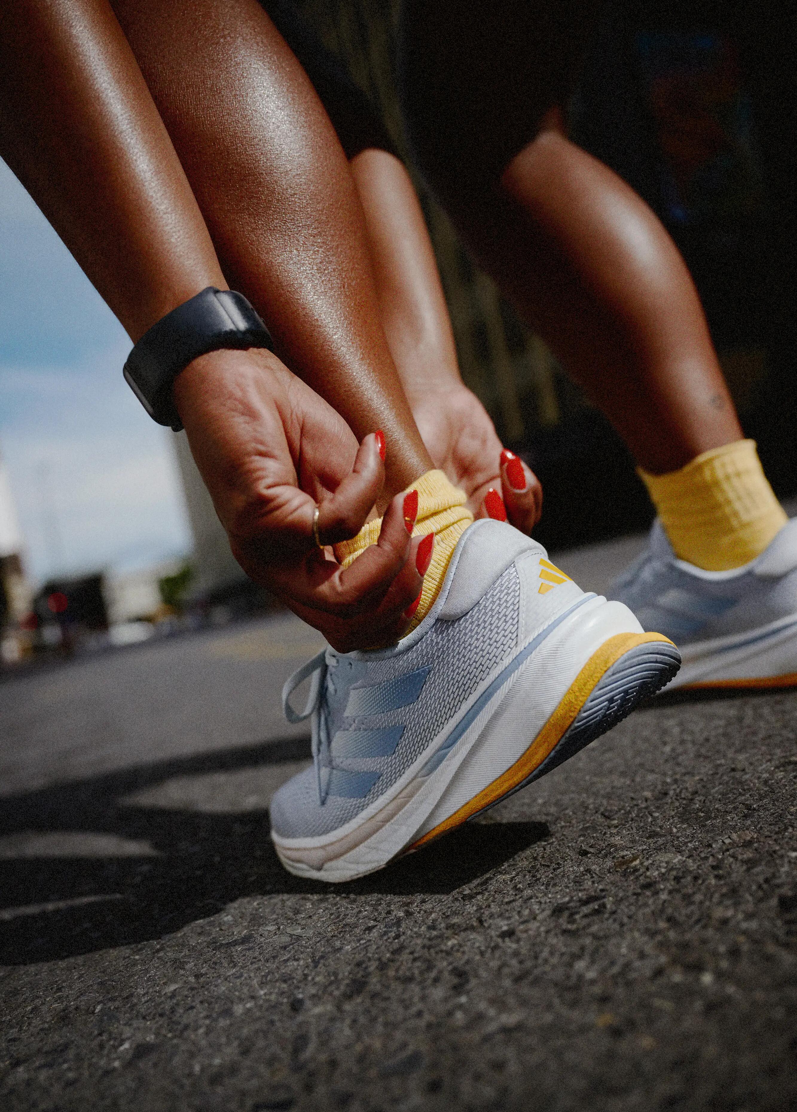 mulher a calçar os tenis de corrida
