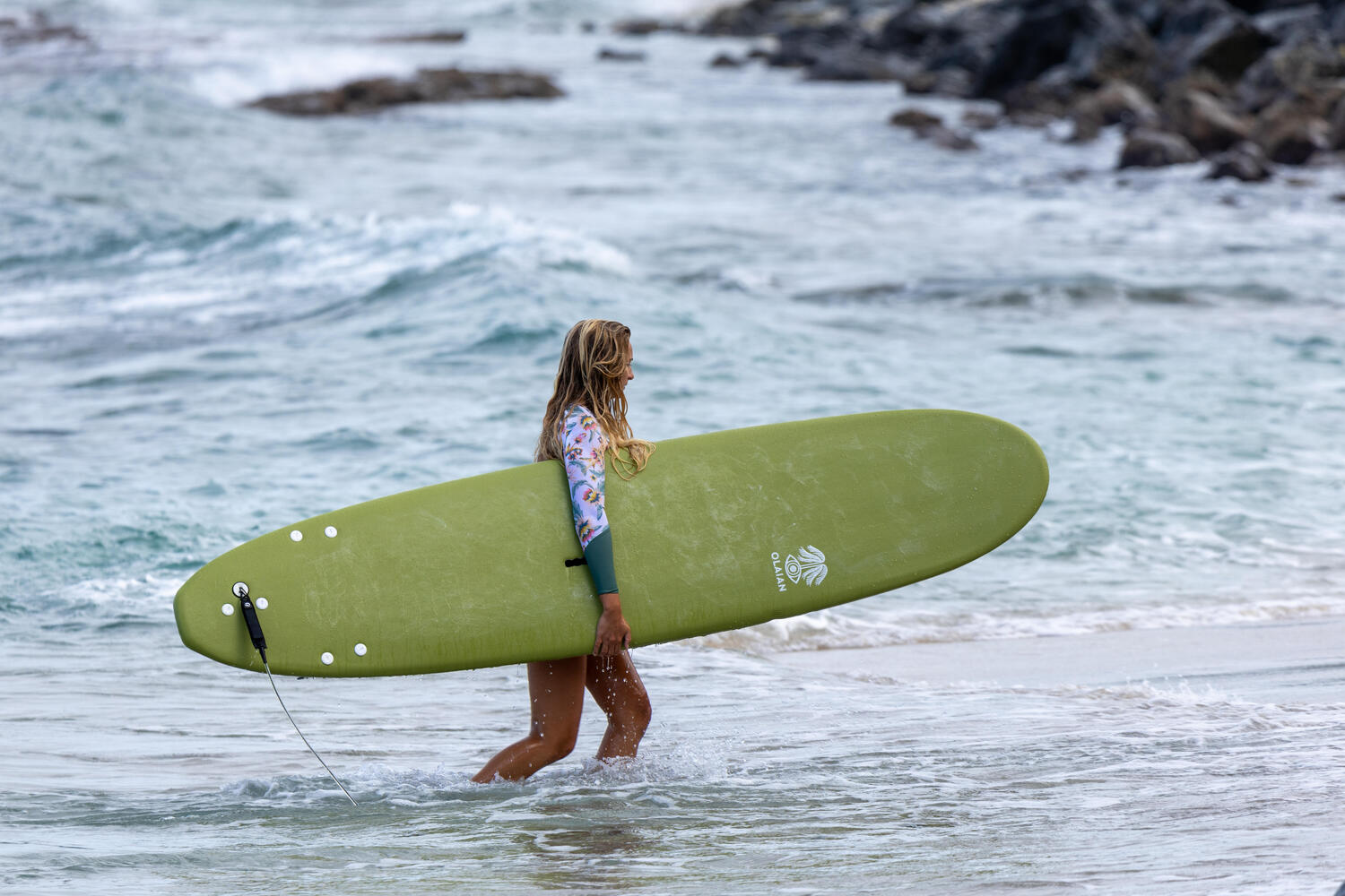 Mujer con una tabla de surf verde