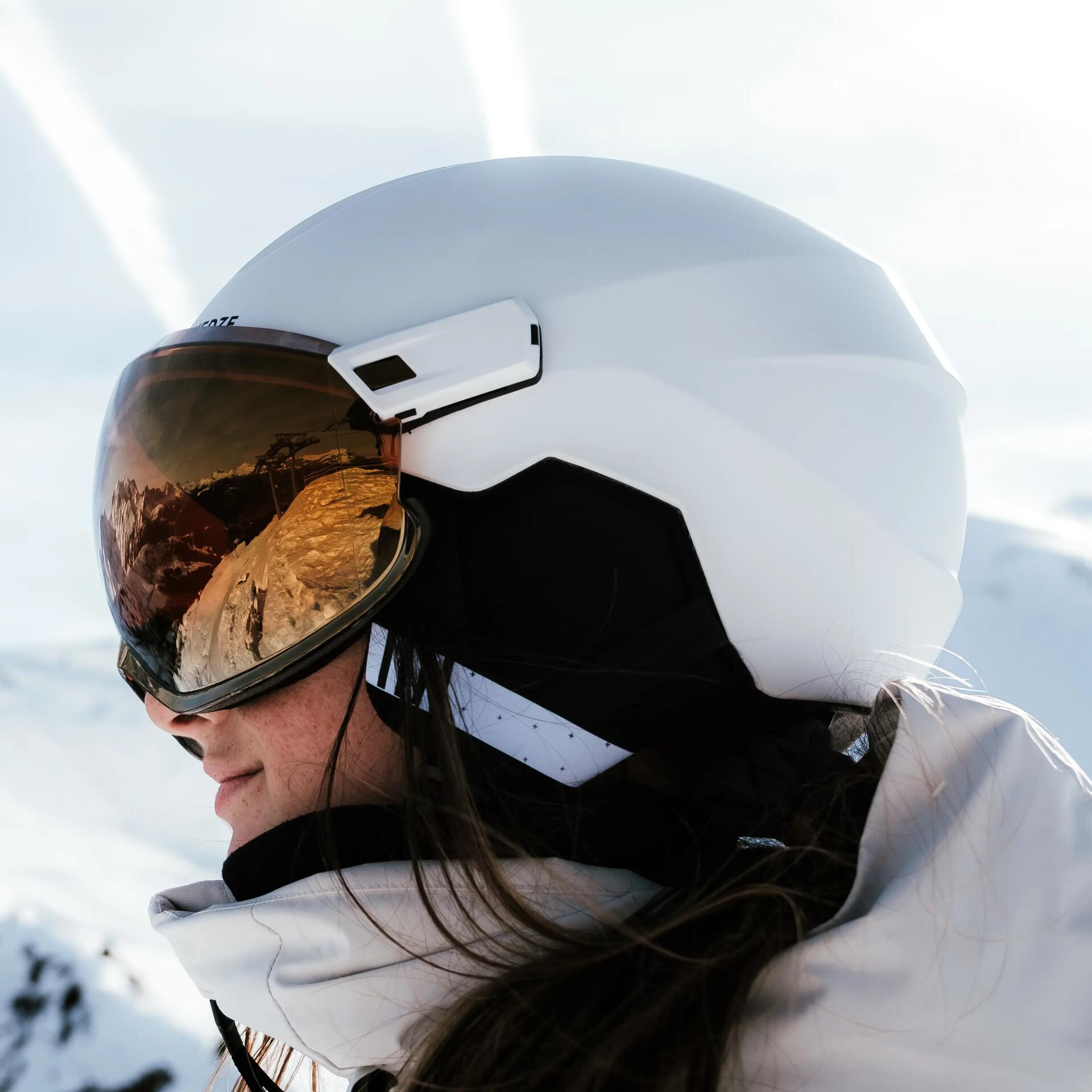 Fille avec casque de ski blanc decathlon en montagne