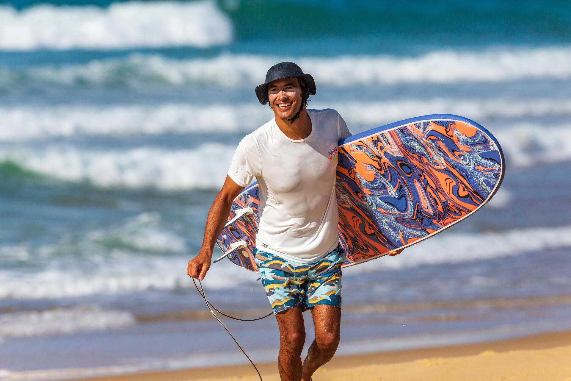 Mężczyzna biegnący z surfingiem w Portugalii