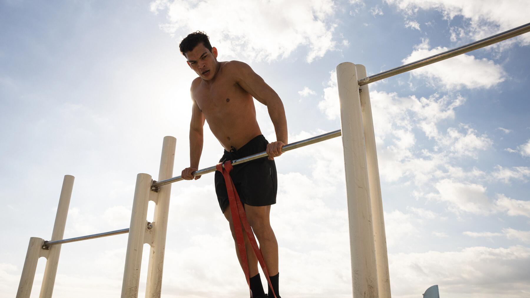Mann trainiert mit Schuhen im Outdoor-Gym