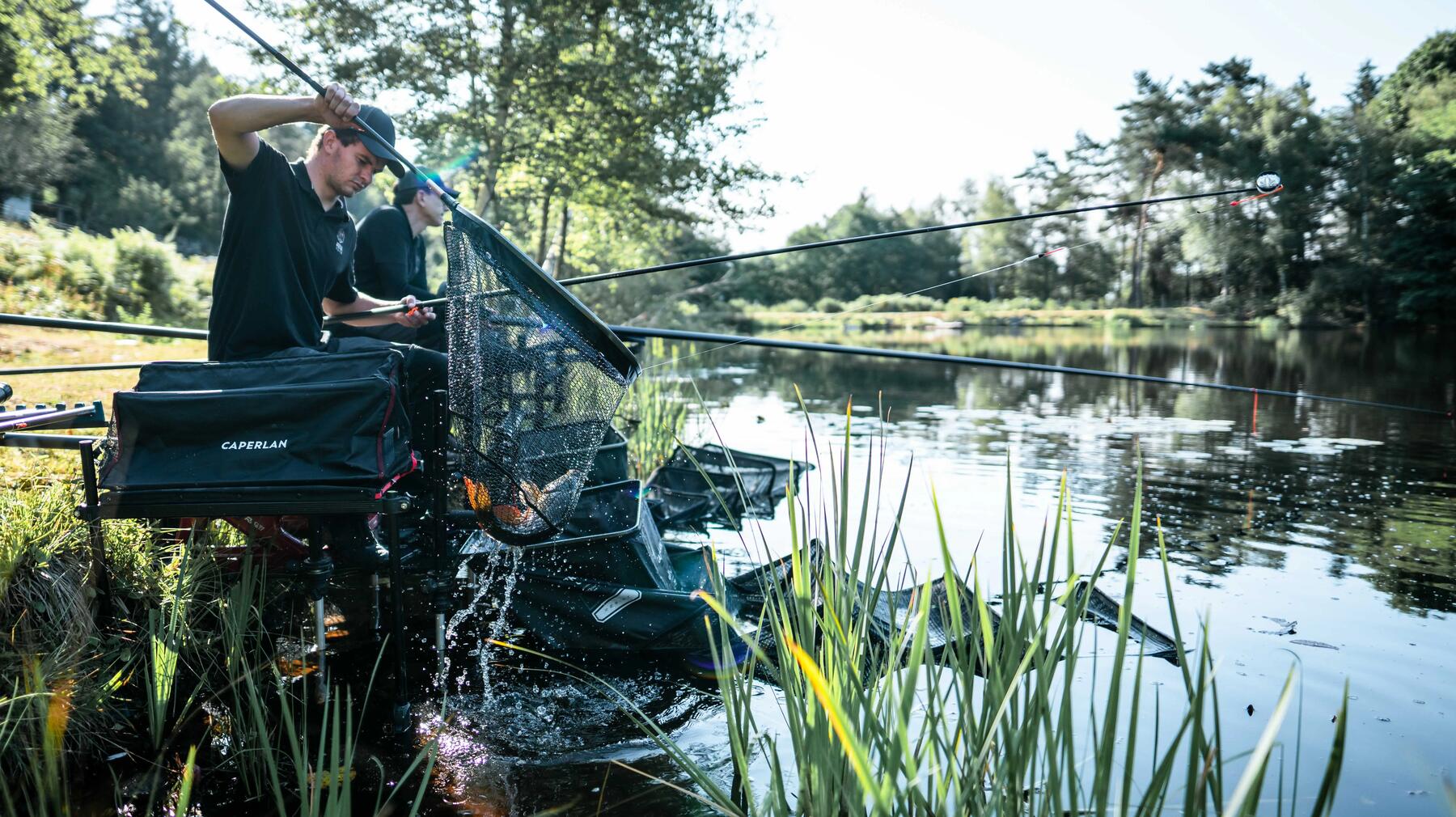 Angler sitzen auf Sitzkiepen beim Angeln