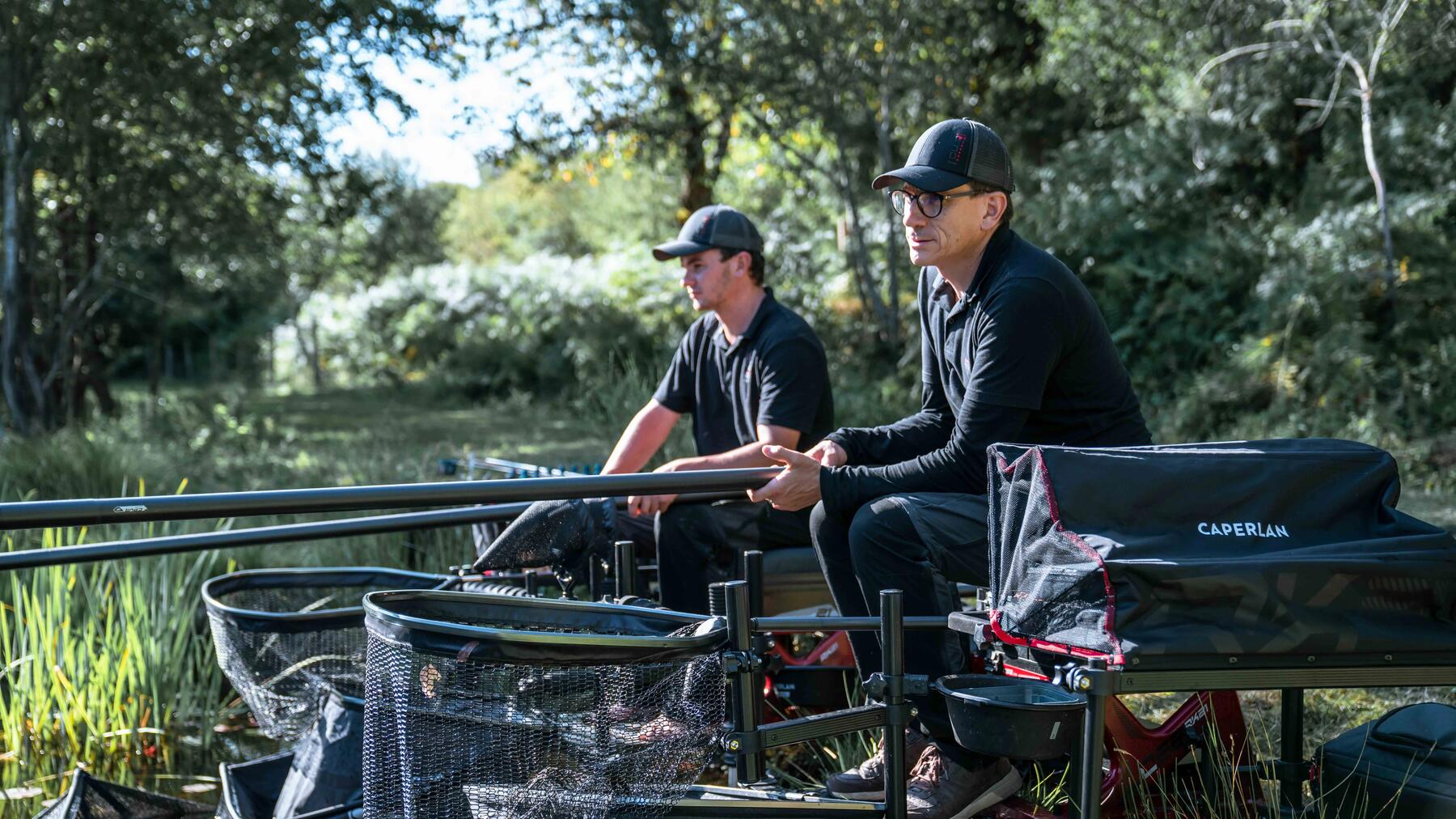 Zwei Angler nutzen eine Sitzkiepe am Ufer