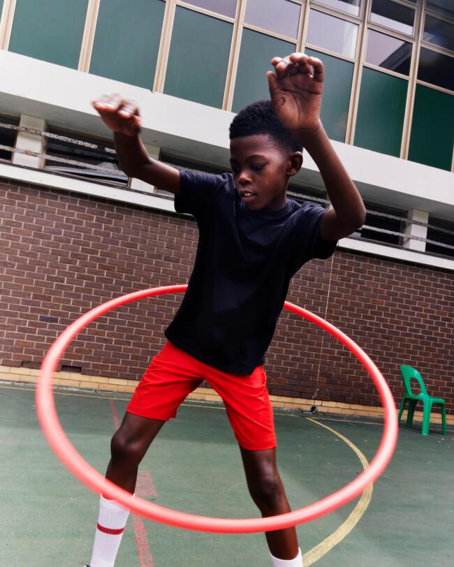 Eine Junge übt mit einem Gymnastikreifen.