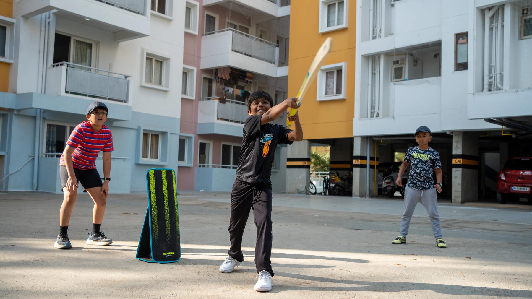 Kinder spielen Cricket in den Gassen eines Wohngebiets