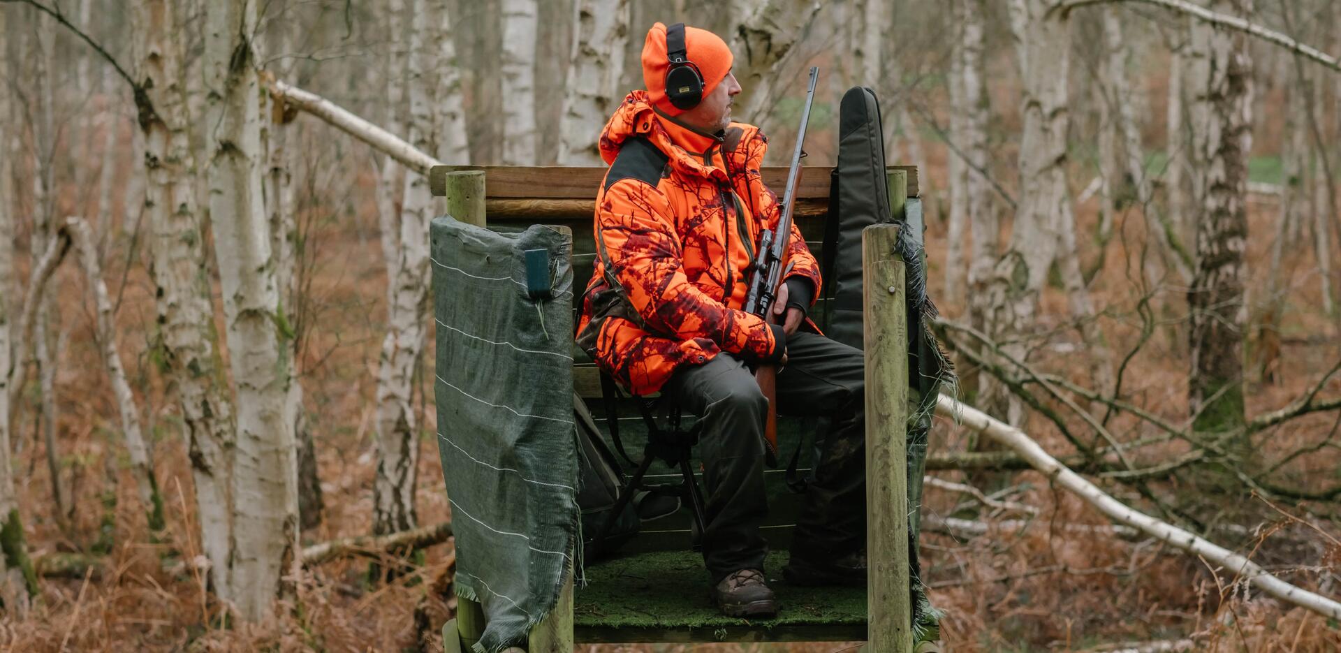 Un chasseur posté sur un mirador assis sur un tabouret