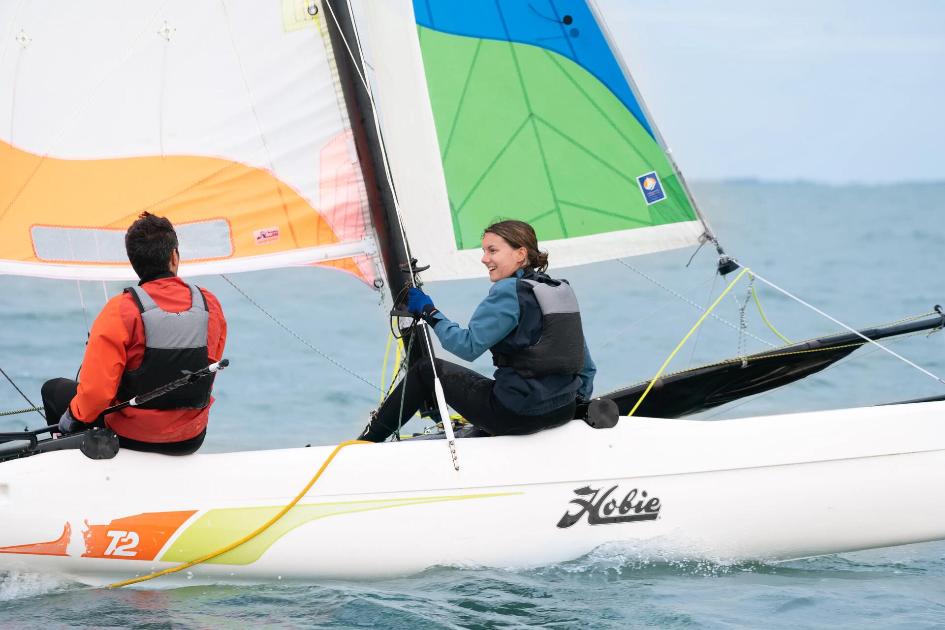 un homme et une femme naviguant sur un catamaran hobie Cat T2