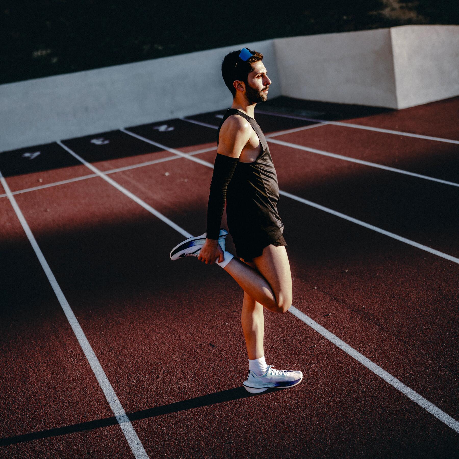Mężczyzna rozciągający mięśnie czworogłowe po bieganiu