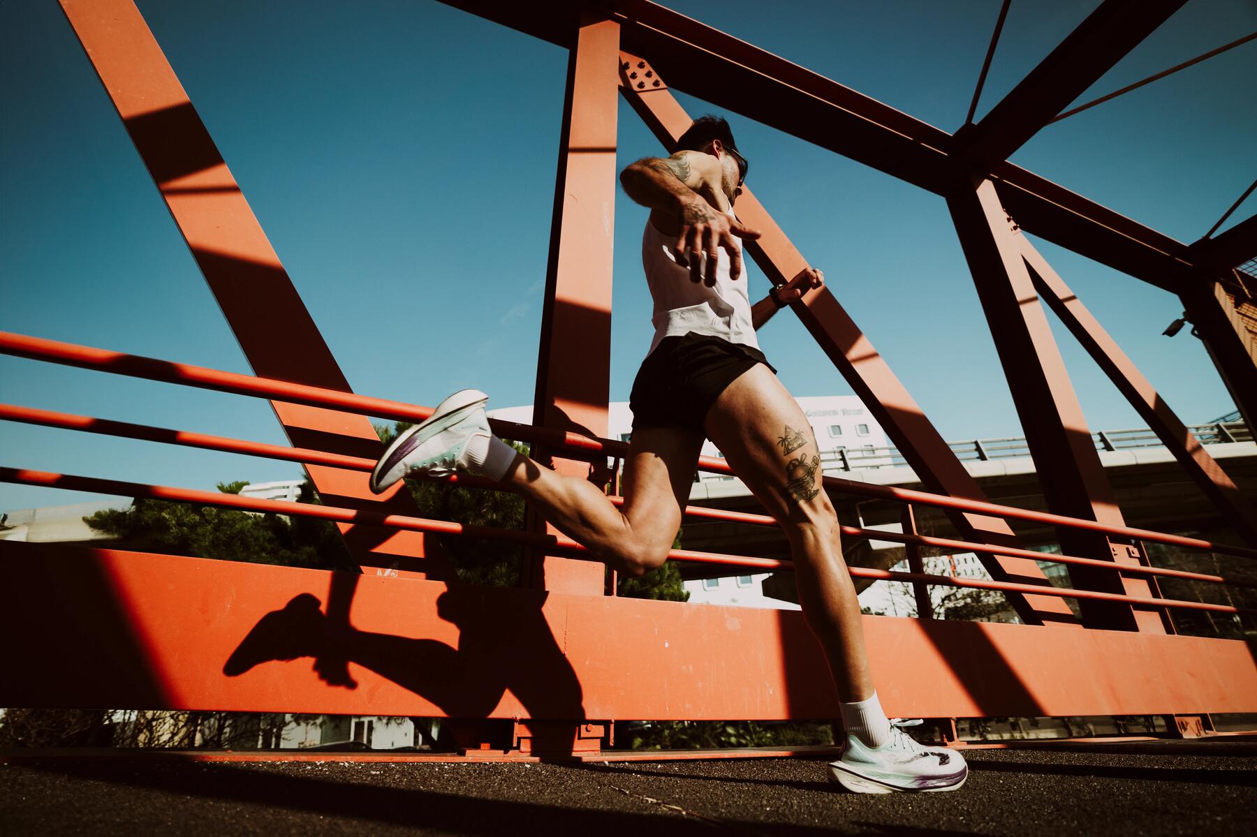 Mężczyzna biegnący po moście w stroju sportowym