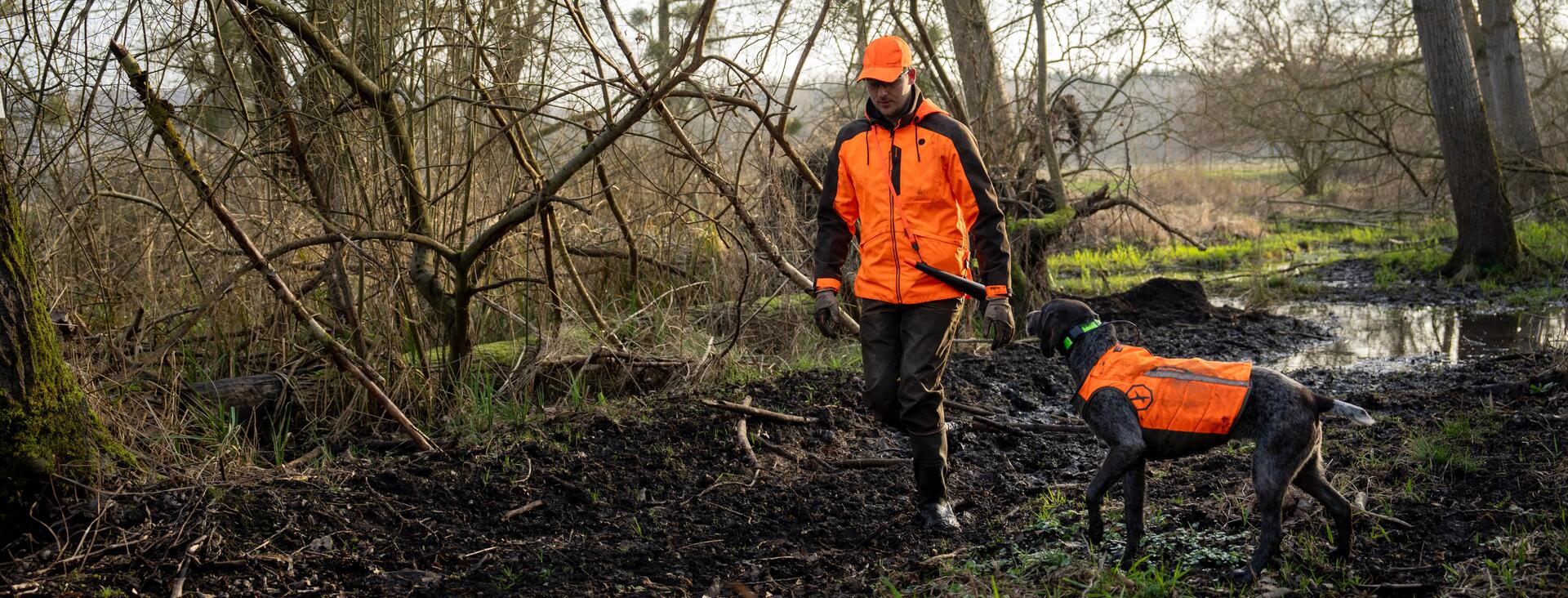 un chasseur traqueur dans un bois avec son chien