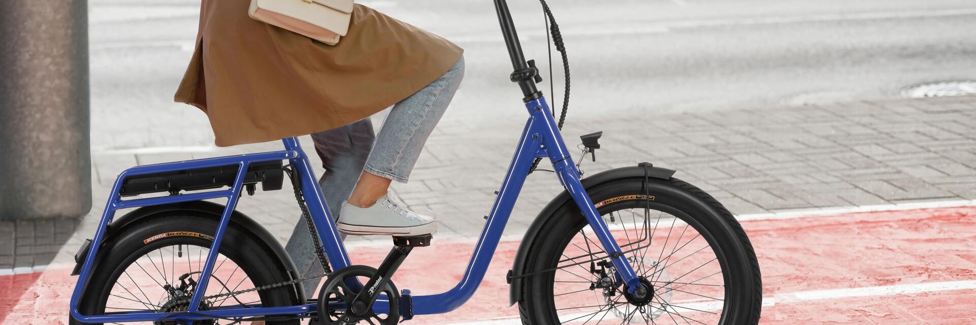 Kobieta jadąca rowerem elektrycznym po ścieżce rowerowej