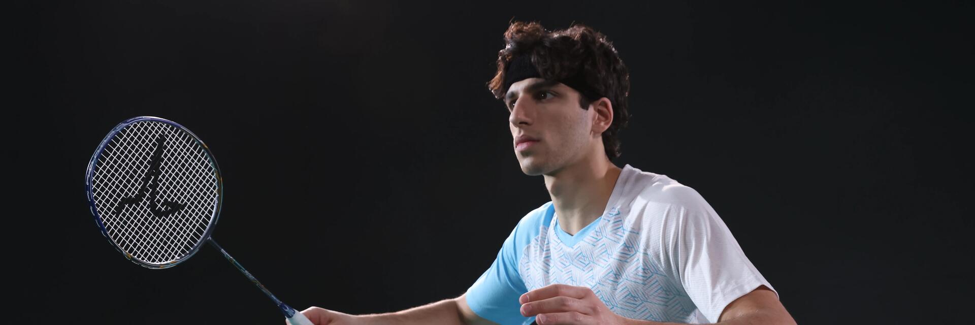 Mężczyzna w odzieży badmintonowej trzymający rakietę do badmintona podczas treningu
