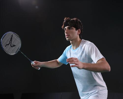 Mężczyzna w odzieży badmintonowej trzymający rakietę do badmintona podczas treningu