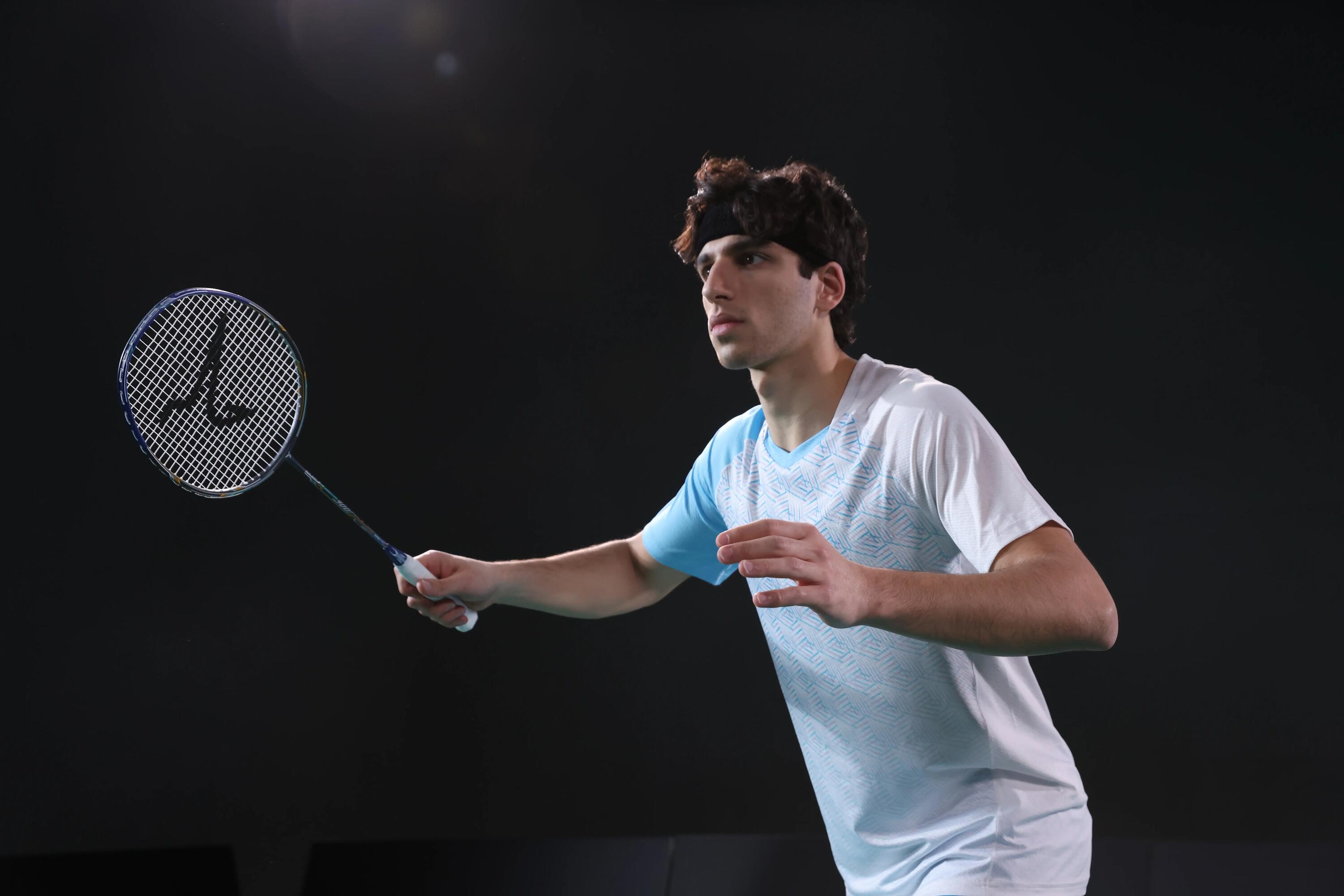 Mężczyzna w odzieży badmintonowej trzymający rakietę do badmintona podczas treningu