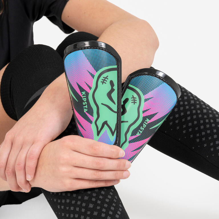 Close-up of a child holding colourful pocket shin guards