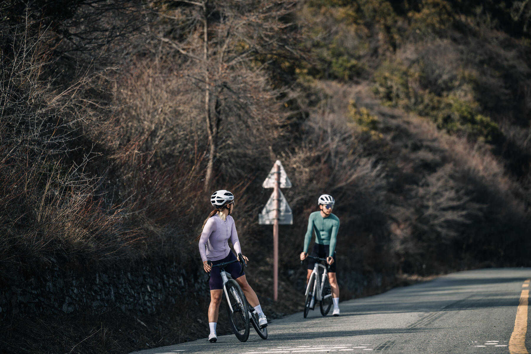 man and woman out cycling and taking a break by the roadside
