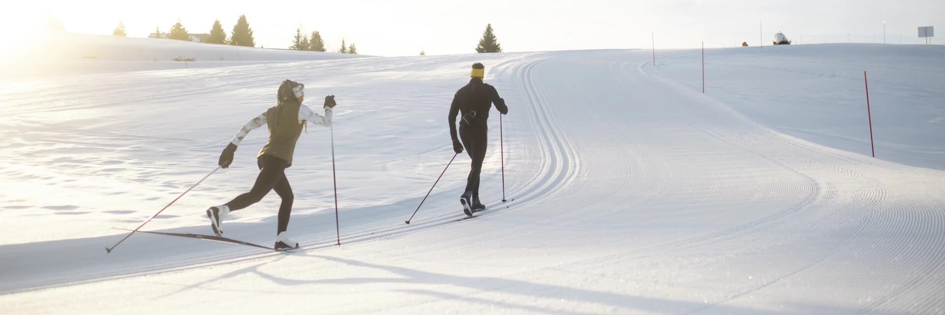 un homme et une femme qui font du ski de fond